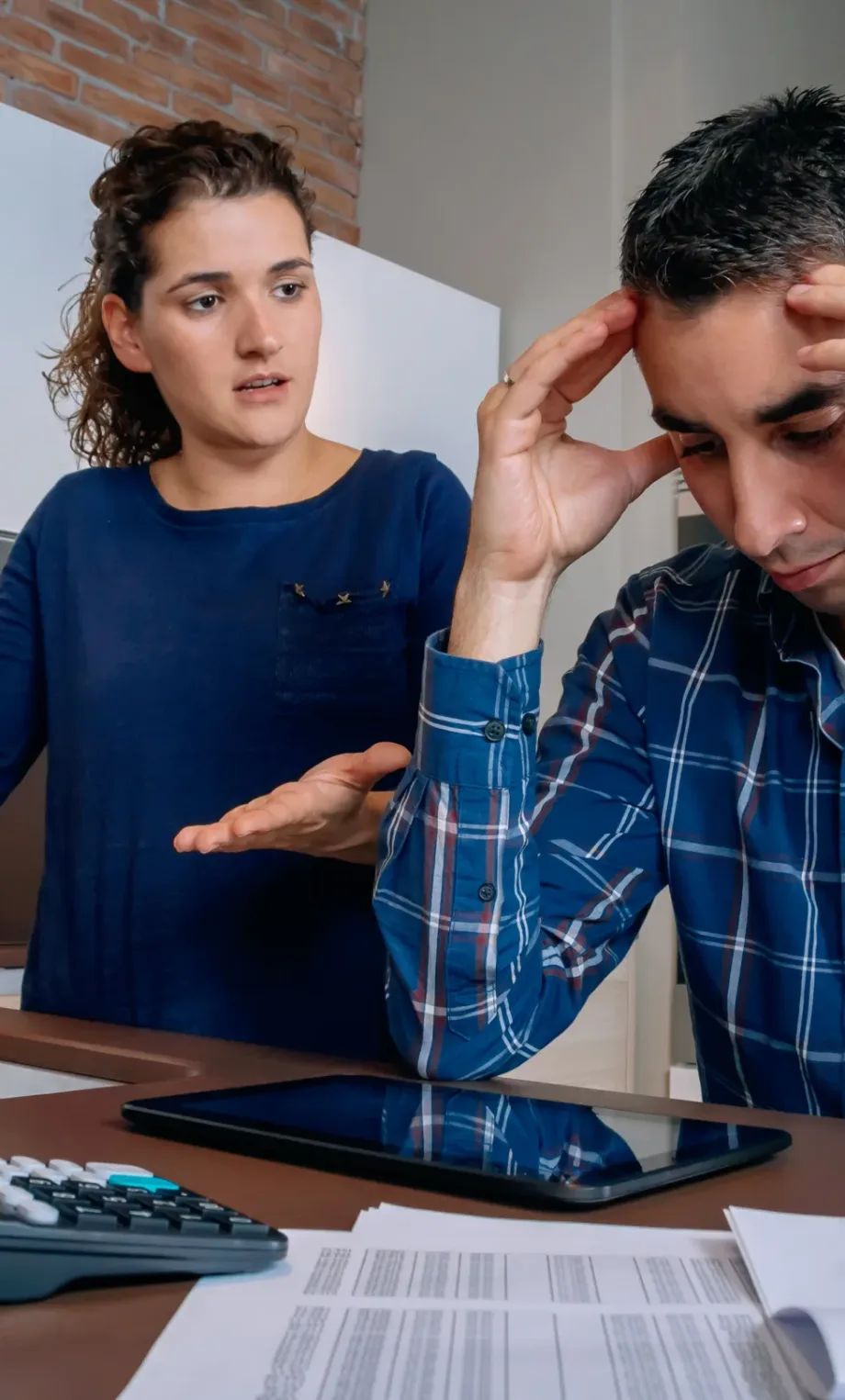Desesperate young couple with many debts reviewing their bills. Financial family problems concept.